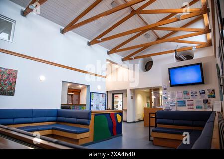 Interno di una moderna sala d'attesa con televisore in uno studio medico Foto Stock