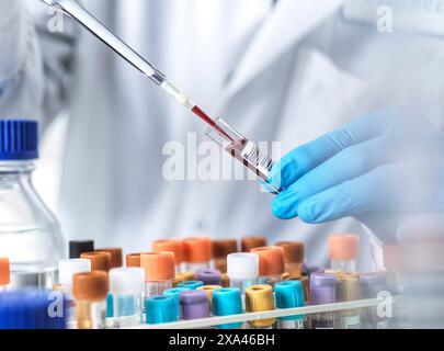Scienziato che pipetta un campione di sangue in laboratorio. Foto Stock
