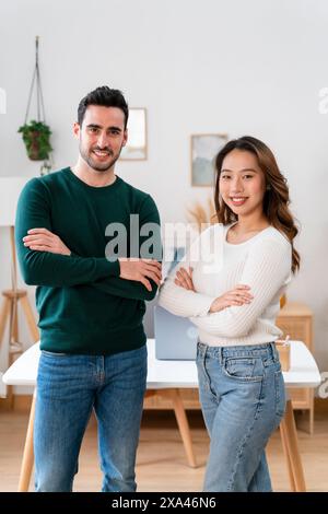 Due adulti sorridenti in piedi con le braccia incrociate Foto Stock