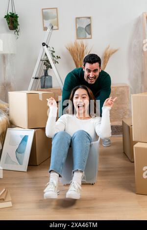 Coppia che si diverte con una scatola mobile a casa Foto Stock