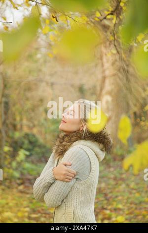 Profilo di giovane donna in autunno Park Foto Stock