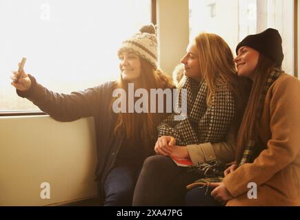 Le ragazze adolescenti seduti sul treno preso Selfie Foto Stock