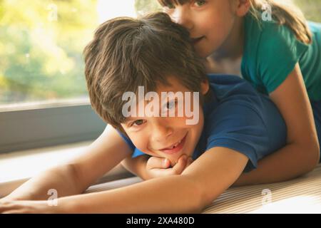 Giovane ragazza distesa sul fratello del Back Foto Stock