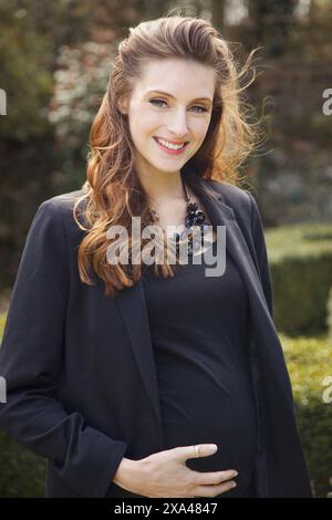 Sorridente donna incinta all'aperto Foto Stock