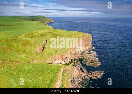 Cullykhan Beach e Bay Aberdeenshire scogliere rocciose Lions Head e shakehole conosciuto come Hell's Lum Foto Stock