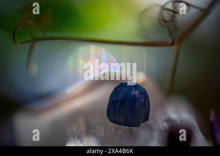 Immagine ravvicinata di un cristallo blu traslucido con sfondo bokeh, che mette in risalto la consistenza del cristallo e le varie sfumature. Foto Stock