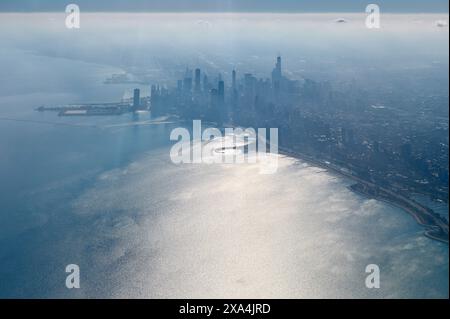 Una vista aerea dello skyline della città lungo la costa, con la luce del sole che si riflette sulla superficie dell'acqua. Foto Stock