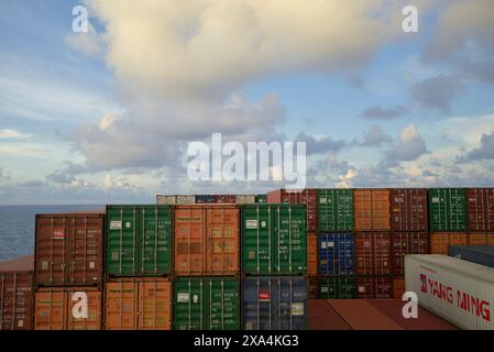 L'immagine mostra una pila di container colorati su una nave da carico con un bellissimo cielo sullo sfondo. Foto Stock
