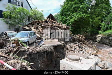 Klaffenbach, Germania. 4 giugno 2024. Auto distrutte lavate da acque alluvionali dopo che una tempesta si trova di fronte a una casa distrutta. Crediti: Bernd Weißbrod/dpa/Alamy Live News Foto Stock