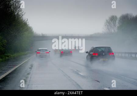 Autostrada M3 trafficata con condizioni di guida molto scarse a causa di pioggia intensa e spruzzi dal punto di vista del conducente Inghilterra Regno Unito Foto Stock