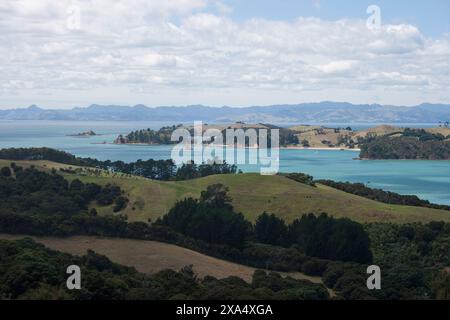 Paesaggio costiero panoramico con colline ondulate e acque cristalline sotto un cielo parzialmente nuvoloso. Foto Stock