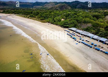 Vista aerea dei surfisti in attesa delle onde su una spiaggia di sabbia tropicale Foto Stock