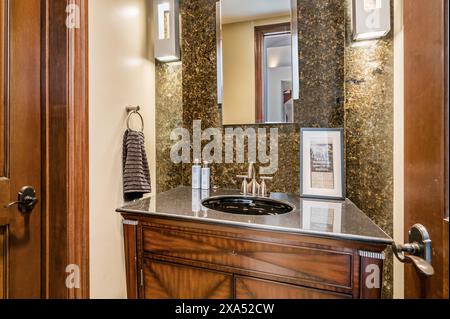 Un bagno con decor bianco e nero e accenti di granito scuro Foto Stock