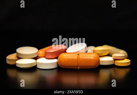 Primo piano di diverse pillole su sfondo nero Foto Stock