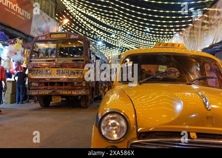 Kolkata, India - 20 novembre 2023: Il tradizionale taxi e taxi Ambassador giallo, segno distintivo delle strade della città, si vede sulle strade della città al n Foto Stock