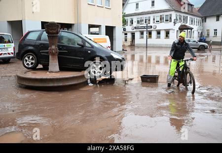 Rudersberg, Germania. 3 giugno 2024. Un'auto lavata via da un'alluvione si trova su una fontana di Rudersberg, Baden-Württemberg. Crediti: Bernd Weißbrod/dpa/Alamy Live News Foto Stock