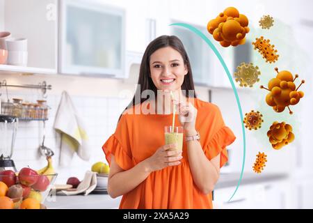 Donna felice con l'immunità che aumenta il cocktail in cucina. Protezione dai virus Foto Stock