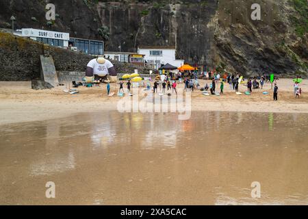 Surfisti e spettatori che si riuniscono per la gara di surf Sand Bandit Showdown al GT Western Great Western Beach di Newquay in Cornovaglia nel Regno Unito. Foto Stock