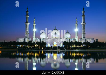 Incredibile vista panoramica della grande Moschea dello Sceicco Zayed di notte con retroilluminazione ad Abu Dhabi Foto Stock