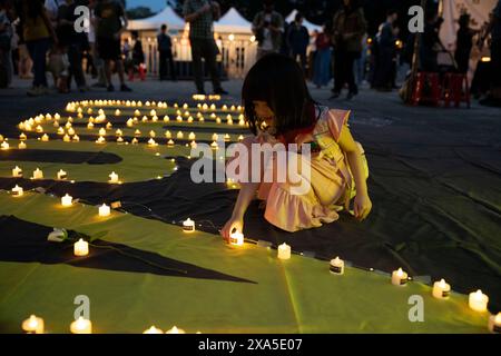 Taipei, Taiwan. 4 giugno 2024. Un bambino colloca una candela senza fiamma sulle lettere 8964 per ricordare la data del massacro di Piazza Tiananmen il 1989, il 4 giugno in una veglia commemorativa del 35° anniversario della repressione, nota anche dai cinesi come incidente del 4 giugno, nella sala commemorativa di Chiang Kai-shek a Taipei, Taiwan. In quel giorno, l'esercito cinese uccise molti manifestanti in piazza Tienanmen e nei dintorni di Pechino che chiedevano una riforma democratica nel 1989. Foto Stock