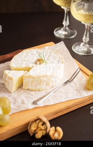 Un piatto con formaggio, noci, uva e bicchieri da vino Foto Stock