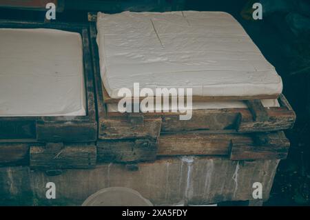 La cagliata di soia viene pressata in una muffa di legno in una tradizionale fabbrica indonesiana di tahu o tofu che mostra prodotti locali genuini e genuini e mezzi di sussistenza Foto Stock