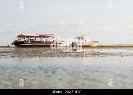 Le due barche che riposano sulla riva durante la bassa marea. Foto Stock