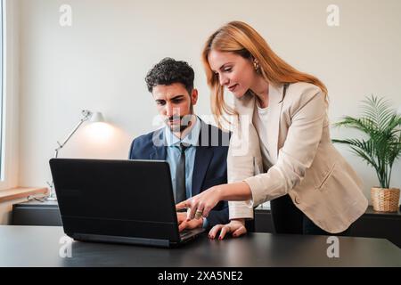 Una donna d'affari e un uomo d'affari che lavorano insieme con un notebook per un progetto di lavoro. Due veri colleghi che collaborano e pianificano utilizzando un computer. Lavoro di squadra dei dipendenti aziendali su un brainstorming. Foto di alta qualità Foto Stock