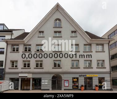 BREGENZ, VORARLBERG, AUSTRIA - 19 MARZO 2023: Un nanometro murale, pari a 0,0000000001 mm, è scritto sulla facciata di un'Austria tradizionale Foto Stock