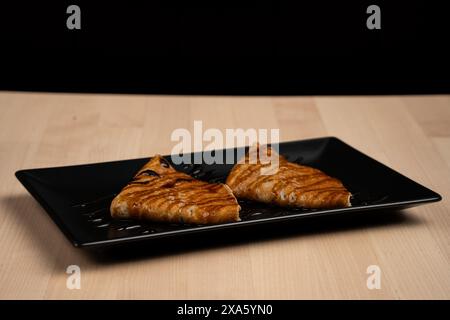 Un primo piano di pancake ricoperti di sciroppo su un piatto servito su un tavolo Foto Stock