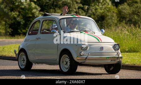 Stony Stratford, Regno Unito - 2 giugno 2024: 1966 Fiat 500 classica bianca su una strada di campagna britannica Foto Stock