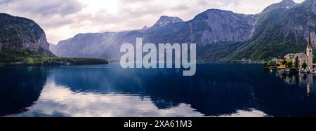 Una vista panoramica di un tranquillo lago circondato da verdi montagne Foto Stock