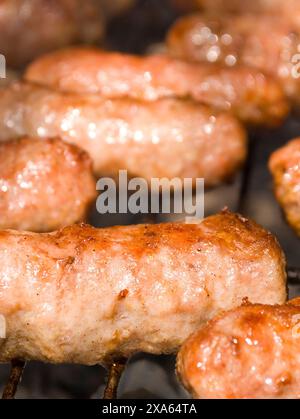 Un primo piano di salsicce grigliate su un barbecue Foto Stock