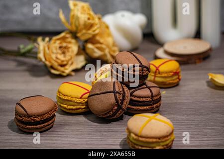 I coloratissimi macaron e le delicate rose disposte su un tavolo Foto Stock