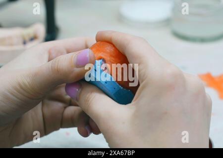 L'odontotecnico crea una base di cera e aggiunge cera per formare lo stampo. Vista laterale. Concetto odontoiatrico Foto Stock