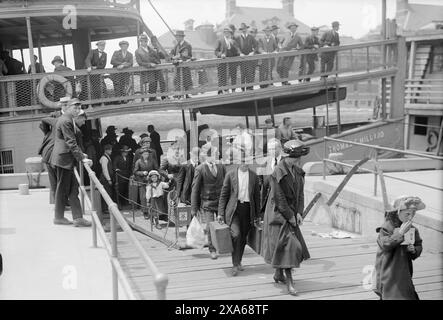 Immigrati che arrivano a Ellis Island nella baia di New York superiore il 1° gennaio 1920. (USA) Foto Stock