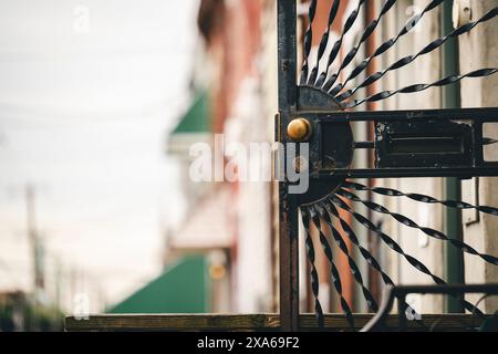 Primo piano della ruota ornata sulla parte superiore di un cancello Foto Stock