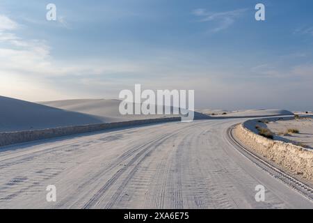 Due auto che guidano su una strada deserta ricoperta di neve Foto Stock