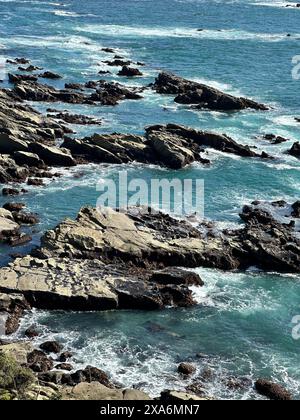 Rocce marine ricoperte di sabbia con acqua sottostante Foto Stock