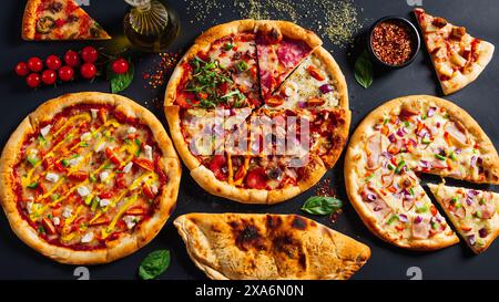 Varietà di pizze con condimenti assortiti su un tavolo Foto Stock