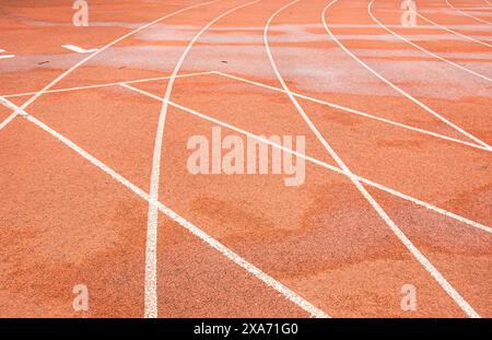 La pista rossa brillante di un'università di Wuhan. La curva bianca si interseca con la linea retta. Foto Stock