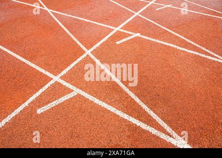 La pista rossa brillante intreccia la traiettoria bianca diritta con la traiettoria bianca curva. Foto Stock