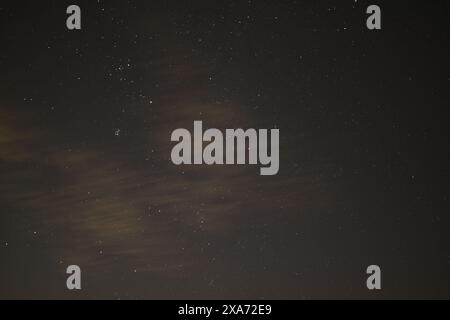 Luna e stelle illuminano il cielo notturno su strade deserte Foto Stock