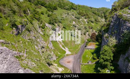 Una strada stretta si snoda attraverso la campagna lungo scogliere rocciose Foto Stock