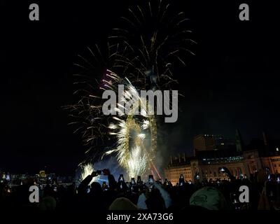 I colorati fuochi d'artificio illuminano il cielo notturno sopra gli edifici della città Foto Stock