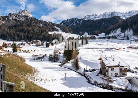 Paesaggio innevato a Selva di Val Gardena, incastonato tra torreggianti montagne dolomitiche, alto Adige, Italia Foto Stock