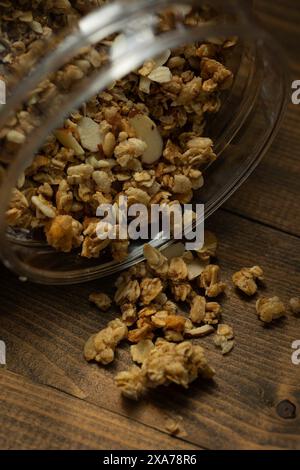 I granuli in una ciotola di vetro su un tavolo di legno. Foto Stock