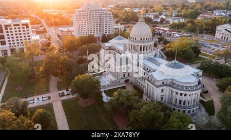 Jackson, Mississippi, Stati Uniti - 23 aprile 2024: La luce del tramonto splende sullo storico Campidoglio e sugli edifici dello skyline del centro di Jackson. Foto Stock