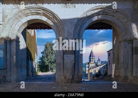 Lo storico monastero dell'abbazia di Cluny attraverso un arco di pietra al tramonto in Borgogna, Francia Foto Stock