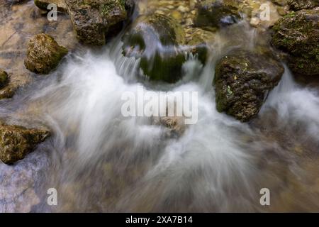 Un colpo d'acqua che scorre sulle rocce del fiume sulla riva Foto Stock